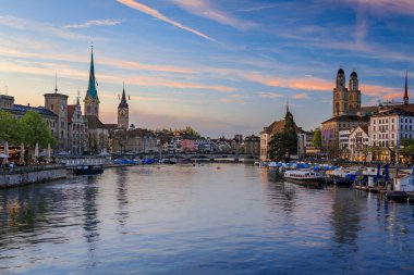 İsviçre, Zürih şehri, alacakaranlıkta. Limmat Nehri 'nin kıyısındaki binalar Altstadt şehir merkezinden akıyor, tekneler liman boyunca akıyor.