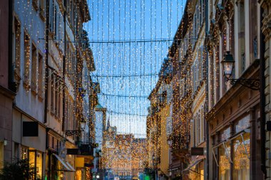 Fransa 'nın Strasbourg kentinin tarihi Grande Ile semtinde Noel Pazarı boyunca ışık saçan şenlik ışıkları dizileri dar bir sokağı aydınlatıyor.