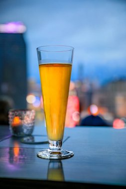 Las Vegas, Nevada, USA - October 24, 2021: A glass of cider overlooks the Strip skyline with neon lights on hotels and casinos after sunset clipart