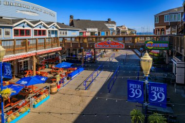 San Francisco, USA - April 30, 2022: Unusually empty Pier 39, famous tourist attraction, with its and shops, restaurants under a clear blue sky clipart