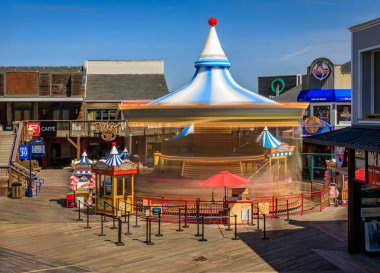 San Francisco, ABD - 30 Nisan 2022: Atlıkarınca renkli atlar ve 39. rıhtımdaki dekorasyonlar, dükkanlar ve restoranlarla çevrili