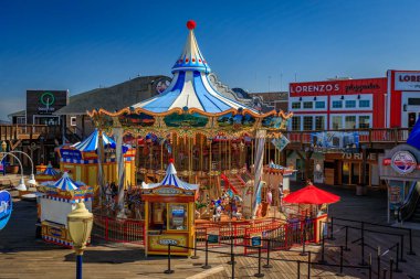 San Francisco, ABD - 30 Nisan 2022: Atlıkarınca renkli atlar ve 39. rıhtımdaki dekorasyonlar, dükkanlar ve restoranlarla çevrili