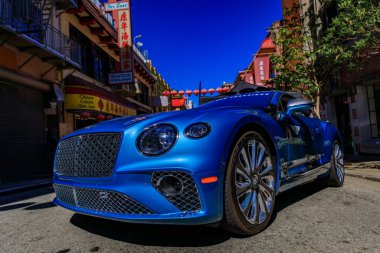 San Francisco, ABD - 24 Eylül 2022 Çin Mahallesi araba fuarında parlak mavi bir Bentley Continental GT, Çin tabelası ve kırmızı fenerleri görünür.