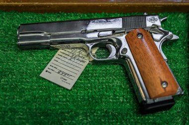 Placerville, USA - October 1, 2022: Rock Island Armory semi-automatic 1911 38 caliber pistol with wooden grips displayed for sale in a gun store clipart