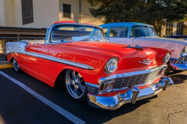 San Bruno, ABD - 7 Ekim 2022: Kırmızı ve beyaz 1956 Chevrolet Bel Air üstü açık, krom kaplama, özel jantlar ve bir araba fuarında düşük süspansiyon