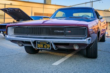 San Bruno, ABD - 7 Ekim 2022: Bir araba fuarında krom ızgara, model amblemi ve Kaliforniya plakalı Burgundy 1968 Dodge Charger