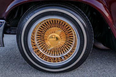 San Bruno, ABD - 7 Ekim 2022: Burgonya Chevrolet Impala altın telli tekerlekler, dönen kapaklar ve bir araba fuarında beyaz duvar lastiği