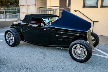 San Bruno, ABD - 7 Ekim 2022: Siyah 1933 Ford Roadster kaputu açık kaput, krom ızgara, ve bir araba fuarında özel tekerlekler, klasik tasarım