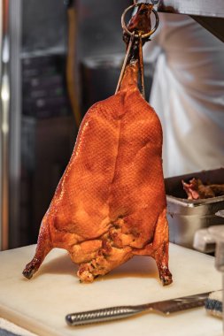 Geleneksel Çin usulü ızgara Pekin ördeği San Francisco 'da bir Çin restoranında mutfakta kancalarda asılı duruyor.
