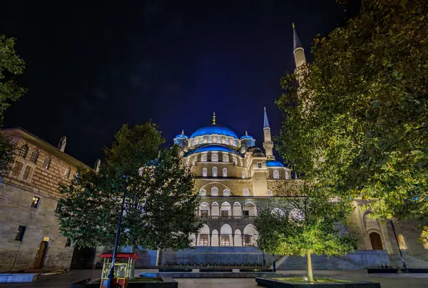 Yeni Cami Yeni Cami Camii 'nin aydınlanmış kubbeleri ve ince minareleri, Türkiye' nin İstanbul kentinde Osmanlı mimarisi sergilenen karanlık gökyüzüne karşı yükseliyor