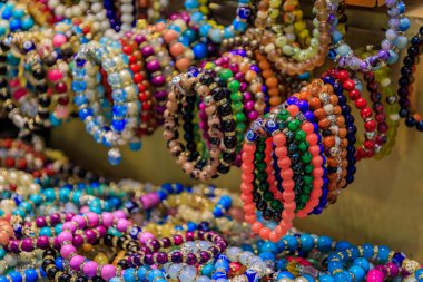 Türkiye 'nin başkenti İstanbul' daki Grand Bazaar 'daki hareketli bir hediyelik eşya dükkanında satışta şeytani göz alıcıları ve değerli taşlar bulunan renkli boncuklu bilezikler sergileniyor