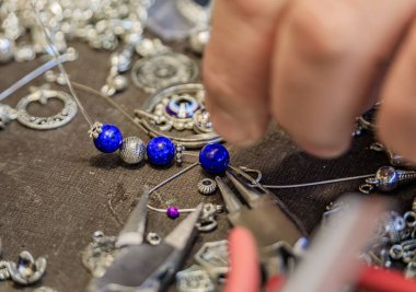 Türkiye 'nin İstanbul kentindeki Grand Bazaar' da özel olarak yapılmış bir bilezik için, lapis lazuli ve gümüş boncuklu kuyumcu çalışma alanı.