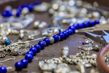 Türkiye 'nin İstanbul kentindeki Grand Bazaar' da özel olarak yapılmış bir bilezik için, lapis lazuli ve gümüş boncuklu kuyumcu çalışma alanı.