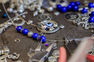 Türkiye 'nin İstanbul kentindeki Grand Bazaar' da özel olarak yapılmış bir bilezik için, lapis lazuli ve gümüş boncuklu kuyumcu çalışma alanı.