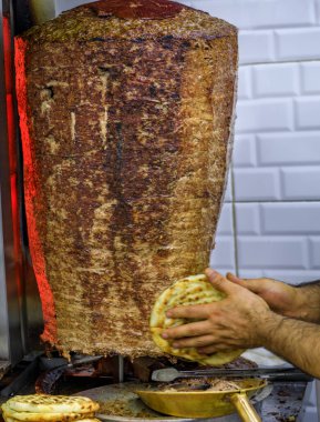 Donör kebap, Türkiye 'nin İstanbul kentindeki Grand Bazaar' da lezzetli ve sulu bir akşam yemeği için dilimlenirken dikey bir tükürükte pişiyor.