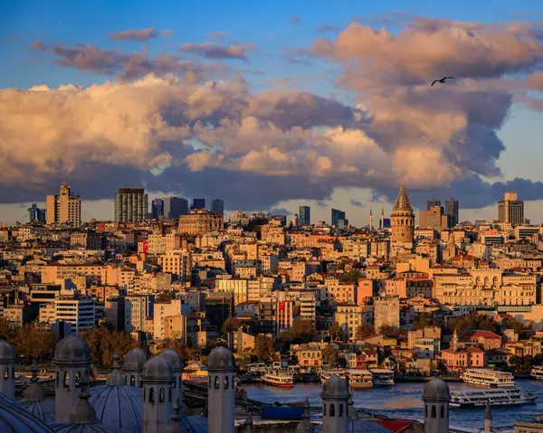 Altın Boynuz boyunca antik ve modern mimarinin panoramik bir görüntüsü, İstanbul, Türkiye 'de dramatik bulutlar altında altın saat ışığı altında yıkandı