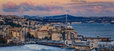 İstanbul, Türkiye 'nin ikonik şehir manzarası olan dramatik bulutlar altında altın saat günbatımında yıkanan Boğaz ve Köprü' nün panoramik manzarası