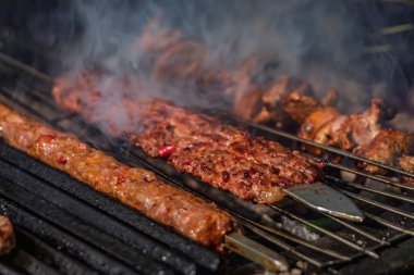 Geleneksel bir Türk pişirme yöntemi olan İstanbul ve Türkiye 'de, Adana bifteği veya kebaplar parlayan kömür közleri üzerine restoranda yavaş yavaş pişiyor