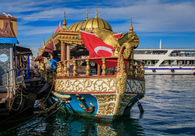 İstanbul, Türkiye - 8 Kasım 2023: Eminonu rıhtımında altın kartal heykeli ve Türk bayrağı ile süslü Balik balık sandviçi