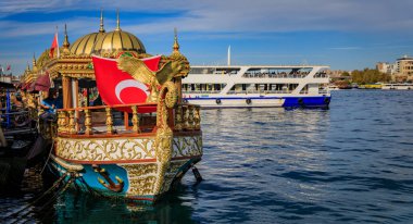 İstanbul, Türkiye - 8 Kasım 2023: Eminonu rıhtımında altın kartal heykeli ve Türk bayrağı ile süslü Balik balık sandviçi