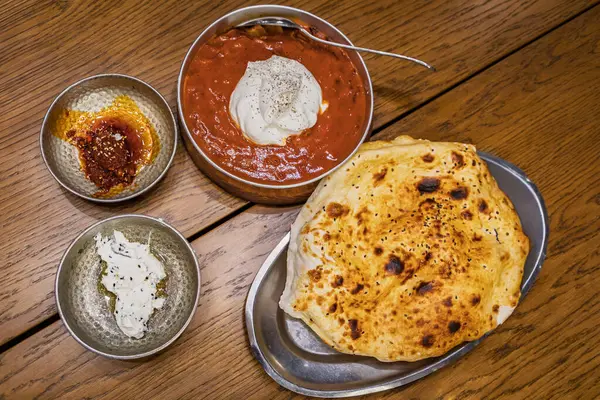 Yoğurtlu domates soslu geleneksel bir Türk yemeği, kabarık düz ekmek ve İstanbul ve Türkiye 'de iki lezzetli sosla servis ediliyor