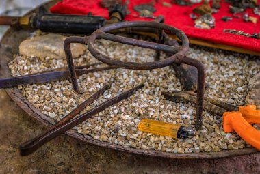 Metali ısıtmak ve lehimlemek için geleneksel araçlar, tripod standları, maşalar ve çakmak, Büyük Pazar kuyumcusu atölyesi, İstanbul Türkiye, sahne arkasında