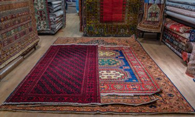 Karmaşık desenli ve canlı renklere sahip geleneksel Türk halıları veya halı, İstanbul, Türkiye 'deki Kapalıçarşıda satılık bir mağazada sergileniyor.