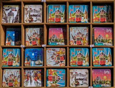 İstanbul 'daki bir hediyelik eşya dükkanının rafındaki Galata Kulesi ve nostaljik tramvay gibi İstanbul simgelerine sahip renkli mıknatıslar.