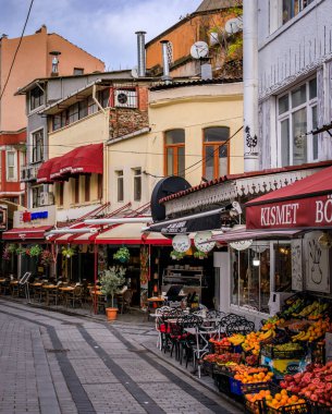 İstanbul, Türkiye - 12 Kasım 2023: Tarihi yarımadada tarihi binalar, dükkanlar, restoranlar ve üretim tezgahlarıyla dolu bir kaldırım taşı caddesi
