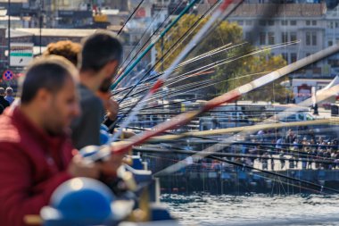 Türkiye 'nin İstanbul kentinde popüler bir uğraş olan Galata Köprüsü' ndeki balıkçılar, çok sayıda oltanın şekillendirilmiş bir bulanıklığı eşsiz bir soyut ön plan oluşturuyor