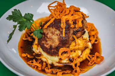 Kızarmış patates püresi ve Zürih, İsviçre 'de leziz bir balzamik sosu olan patates püresinin üzerinde bir tabak gurme İsveç köftesi.