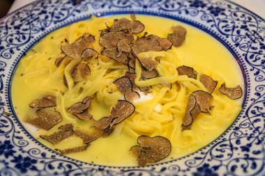 Tıraşlı trüf mantarı ve İsviçre 'nin Zürih kentindeki bir restoranda servis edilen kremalı burrata peyniri ile kaplı taze linguini tabağı.