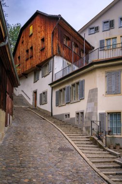 Zürih 'in Eski Kenti veya Altstadt kentindeki dik kaldırım taşı caddesinde geleneksel mimari ve ahşap cephelerin yer aldığı tarihi binalar sıralanmıştı.