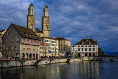 Altstadt 'taki Limmat Nehri üzerinde klasik binalar ve ikiz ikiz Grossmunster Roma katedrali, Zürih, İsviçre