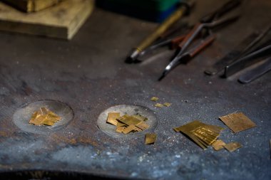 İsviçre, Zürih 'te özel metal işleme aletleri ve malzemelerle dolu bir kuyumcu tezgahı, metal matkap uçları ve bir şişe kuyumcu asidi.