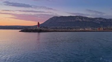 Costa Blanca, Denia Alicante 'nin büyüleyici deniz feneriyle deniz manzarası ve gün batımında Montgo Dağı ile seyahat ediyor.