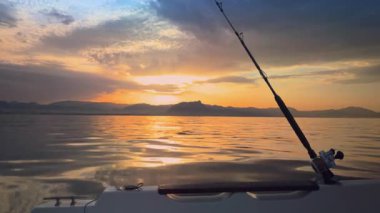 Güneş, Alicante Denia 'nın baş döndürücü sahil şeridinde okyanusun üzerinde batarken Costa Blanca boyunca sakin bir tekne balıkçılığı gezisi.