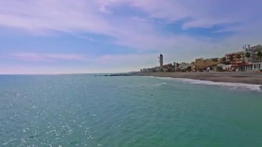 Akdeniz kıyısında, Castellon Costa del Azahar sahilinde, palmiye ağaçları ve berrak suları ve deniz kıyısındaki yerleşim alanları olan Nules plajı.