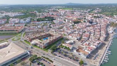 Algarve geleneksel mimarisinin Tavira şehir manzarası ve rıhtım boyunca uzanan nehir tekneleri.