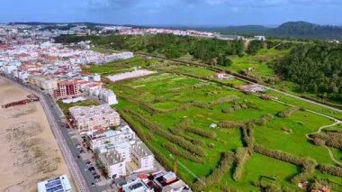 Portekiz 'in Atlantik Okyanusu kıyısındaki Nazare şehir ve plajının havadan görünüşü