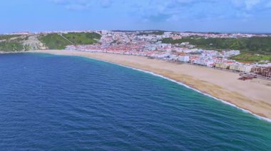 Portekiz 'in Atlantik Okyanusu kıyısındaki Nazare şehir ve plajının havadan görünüşü