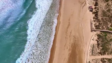 Algarve Portekiz 'de Meia Praia plaj sörfünün insansız hava aracı görüntüsü.