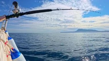 Akdeniz 'de mavi gökyüzünün altında tuzlu su oltası ve olta balığı.