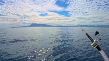 Akdeniz 'de mavi gökyüzünün altında tuzlu su oltası ve olta balığı.