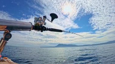 Akdeniz 'de mavi gökyüzünün altında tuzlu su oltası ve olta balığı.