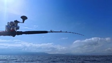 Balıkçı oltası ve balıkçı oltası okyanus denizinde tuna balığı avlamak için tekneden çekiliyor.