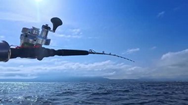Balıkçı oltası ve balıkçı oltası okyanus denizinde tuna balığı avlamak için tekneden çekiliyor.