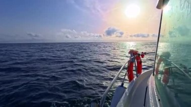 Güneşin doğuşuyla birlikte teknenin yan camı okyanus denizinde güzel güneş ışığıyla yelken açıyor.