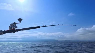 Balıkçı oltası ve balıkçı oltası okyanus denizinde tuna balığı avlamak için tekneden çekiliyor.