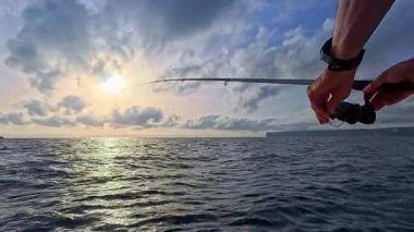 Teknede tuzlu su oltası avcılığı, balıkçı teknesi okyanusta el yordamıyla yüzüyor.